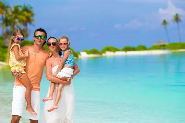 Familia feliz de cuatro en vacaciones de playa — Foto de Stock