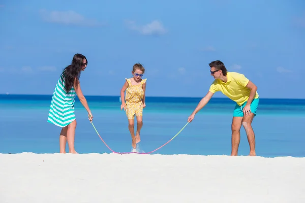 Gelukkige familie spelen samen op witte strand — Stockfoto