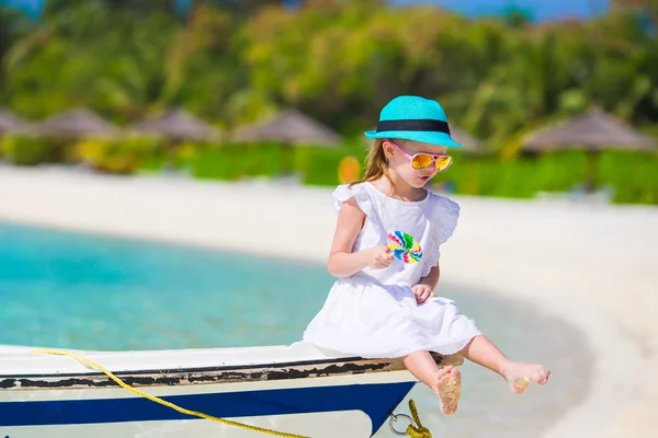 Adorable little girl with lollipop on tropical beach — Stock Photo, Image