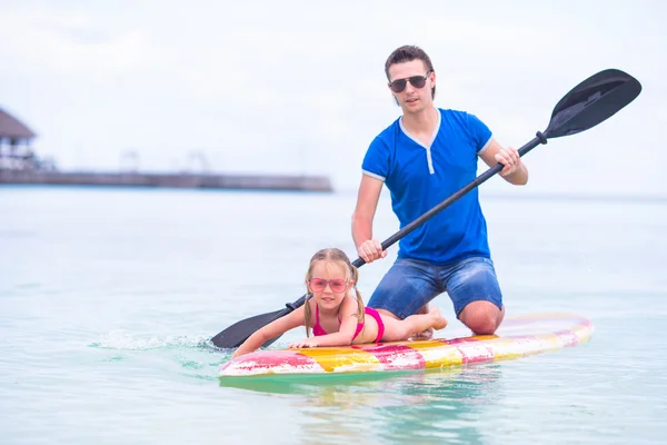 Menina e jovem pai se divertem na prancha de surf — Fotografia de Stock