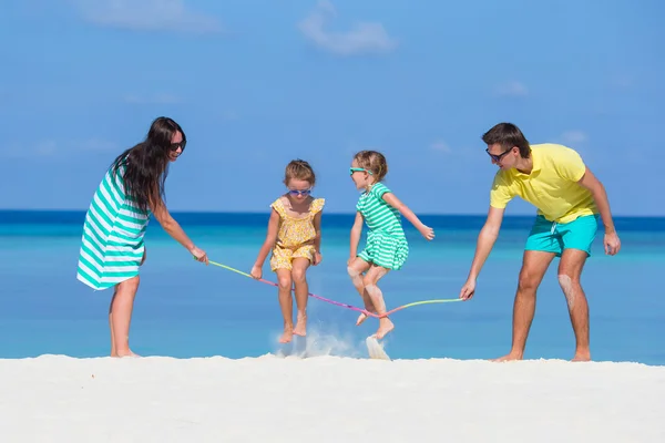 Счастливая семья играет вместе на белом пляже — стоковое фото