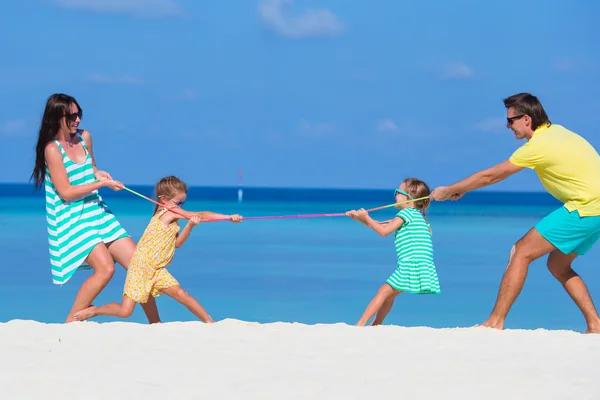 Familia feliz jugando juntos en la playa blanca — Foto de Stock