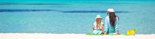 Kleines Mädchen und junge Mutter entspannen sich am Strand — Stockfoto