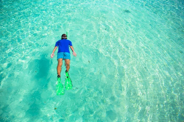 若い男が明確な熱帯のターコイズ ブルーの海でシュノーケ リング — ストック写真