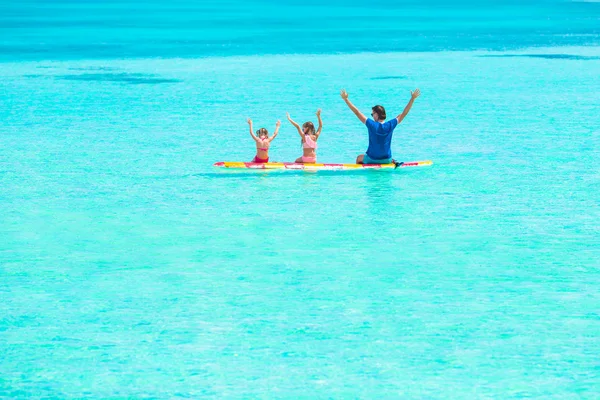 Kleine Mädchen und junger Papa auf dem Surfbrett in den Sommerferien — Stockfoto