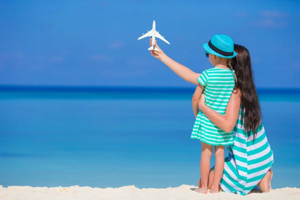 젊은 여자와 해변에서 비행기의 미니어처와 어린 소녀 — 스톡 사진