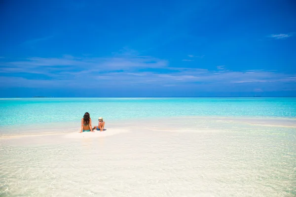 Niña y madre joven durante las vacaciones en la playa — Foto de Stock