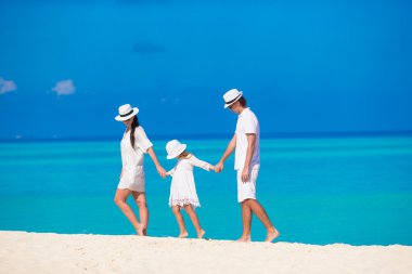 Genç anne-baba ve çocuk beyaz tropikal plaj