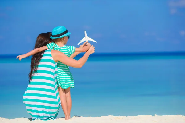 Young woman and little girl with miniature of airplane at beach — Stock Photo, Image