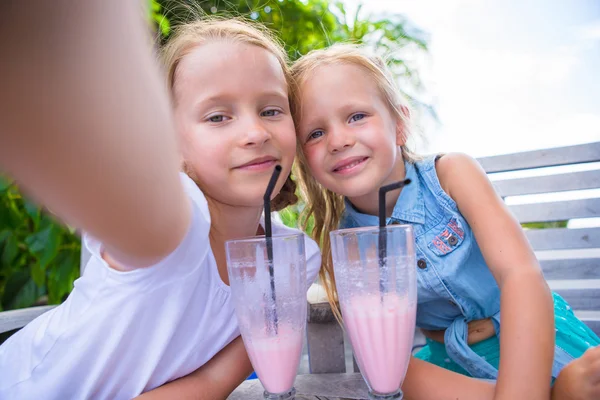 Little girls taking selfie and drinking tasty cocktails at tropical resort — Stock Photo, Image