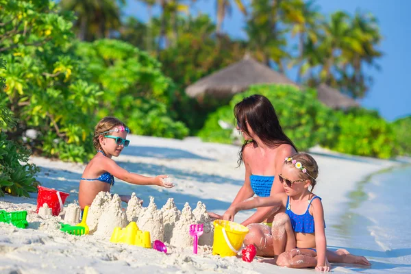 Niñas y madre feliz jugando con juguetes de playa en vacaciones de verano —  Fotos de Stock