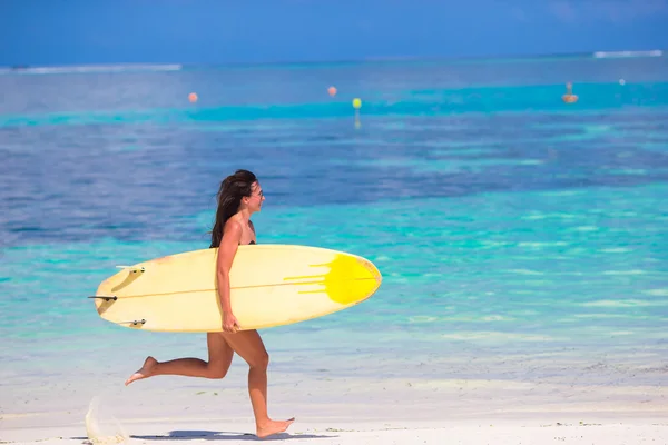 Χαρούμενος νεαρός surf γυναίκα που τρέχει στην παραλία με μια σανίδα του σερφ — Φωτογραφία Αρχείου