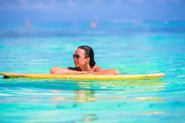 ターコイズ ブルーの海でのサーフィン若いサーファーの女の子 — ストック写真