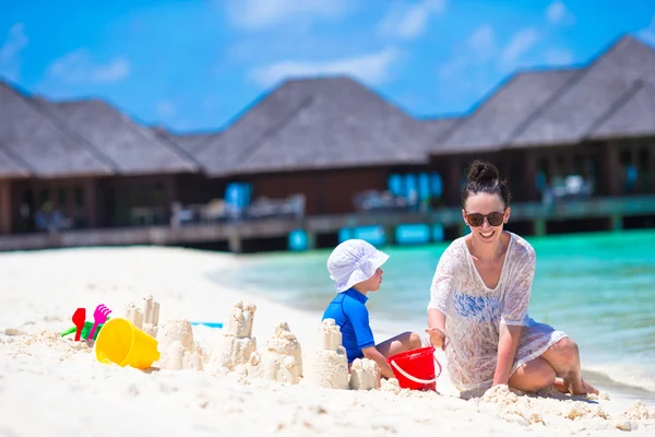 Menina e mãe feliz brincando com brinquedos de praia nas férias de verão — Fotografia de Stock