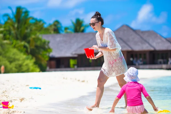 Mała dziewczynka i szczęśliwą matką gra z plaży zabawki na wakacje — Zdjęcie stockowe