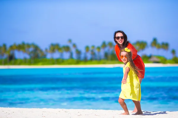 Niña y madre joven durante las vacaciones en la playa — Foto de Stock