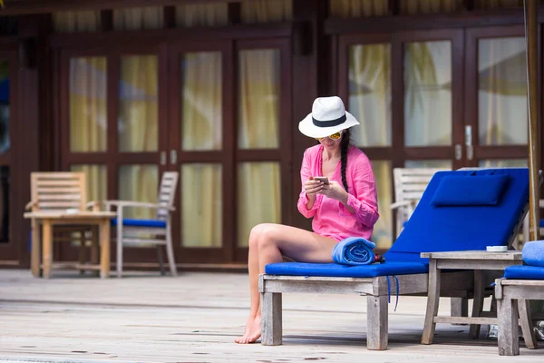 Unga vackra kvinnan talar på vita stranden telefon — Stockfoto