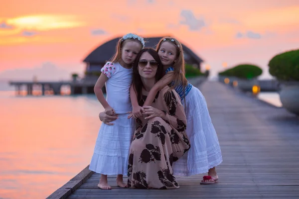 Silueta mladá matka a dva její holčičky při západu slunce — Stock fotografie