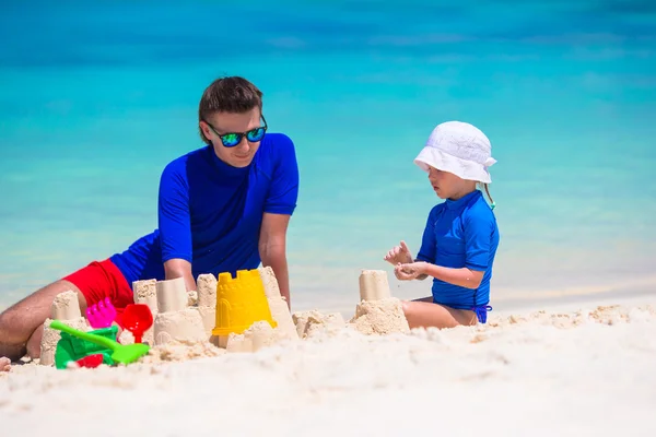 Adorável menina e feliz pai brincando com brinquedos de praia em férias de verão — Fotografia de Stock