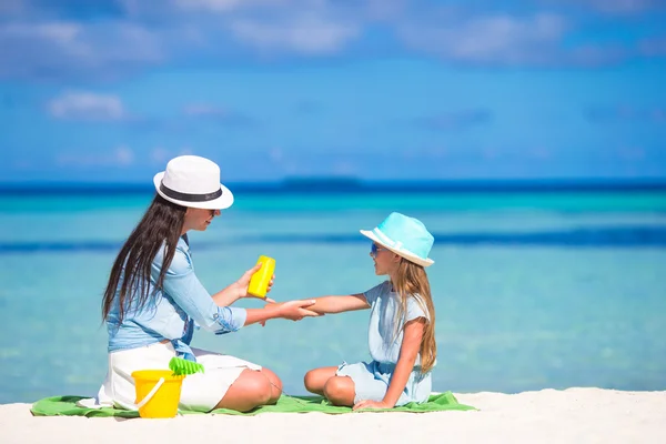 Junge Mutter trägt Sonnencreme auf ihr Kind auf — Stockfoto