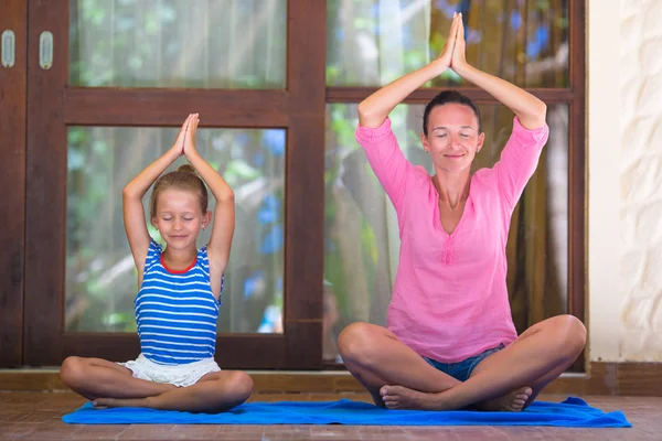 Mujer joven y niña haciendo ejercicio de yoga al aire libre en la terraza — Foto de Stock