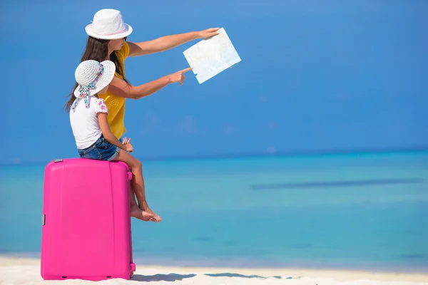 Mother and little daughter with big bag on white beach — Stock Photo, Image