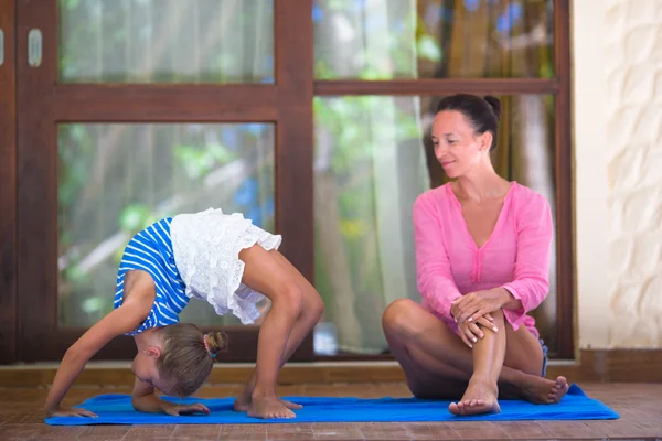 Egzersiz genç kadın ve küçük kızı yoga yaparken açık terasta — Stok fotoğraf