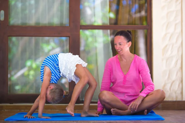 Egzersiz genç kadın ve küçük kızı yoga yaparken açık terasta — Stok fotoğraf