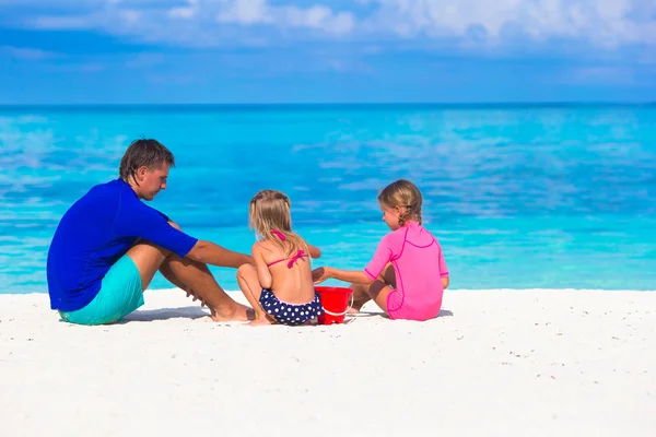 Ragazze adorabili e padre felice che gioca con i giocattoli sulla spiaggia in vacanza estiva — Foto Stock