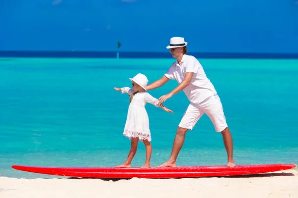 Father with little daughter at beach practicing surfing position — Stock Photo, Image