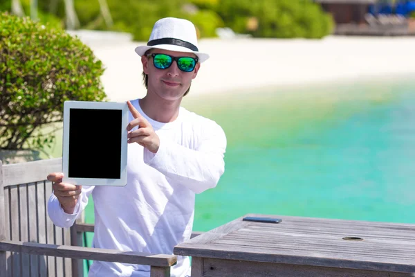 Jongeman met tablet computer tijdens tropische strandvakantie — Stockfoto