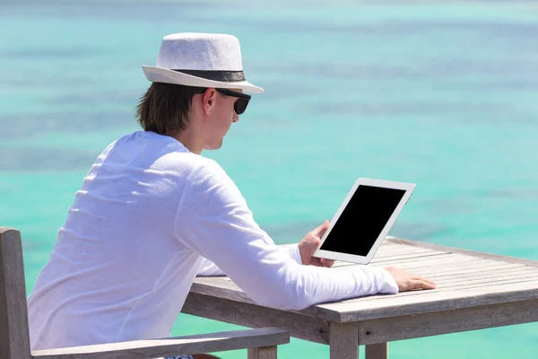 Junger Mann mit Laptop am tropischen Strand — Stockfoto