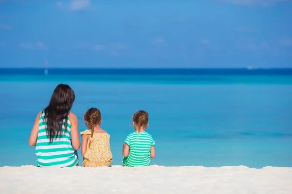 Schattige kleine meisjes en jonge moeder op tropisch wit strand — Stockfoto