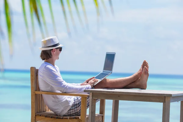 Jovem com computador tablet durante as férias na praia tropical — Fotografia de Stock