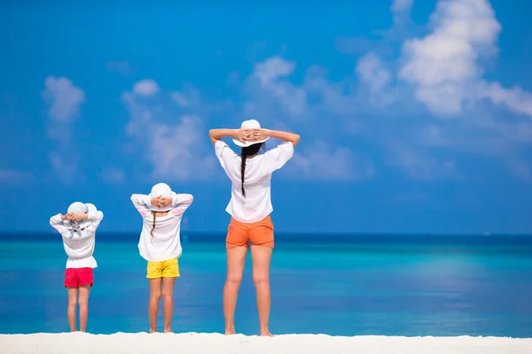 Schattige kleine meisjes en jonge moeder op tropisch wit strand — Stockfoto