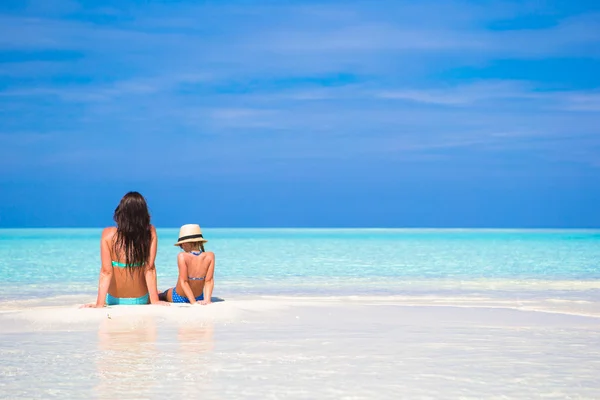 Niña y madre joven durante las vacaciones en la playa — Foto de Stock