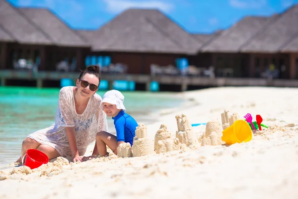 Holčička a šťastná matka hrát s hračkami, pláž na letní dovolenou — Stock fotografie