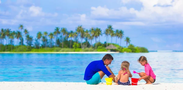 Adorables niñas y papá jugando con juguetes de playa en las vacaciones de verano — Foto de Stock