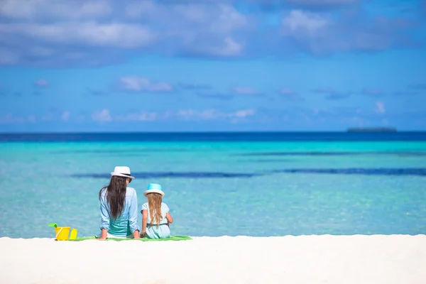 Klein meisje en jonge moeder ontspannen aan het strand tijdens tropische vakantie — Stockfoto