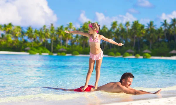 Padre con hija pequeña en la playa practicando surf posición — Foto de Stock