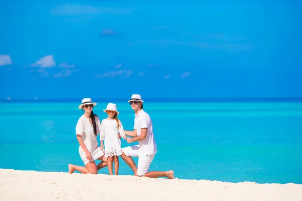 Yaz tatilinde beyaz plajda genç bir aile. — Stok fotoğraf