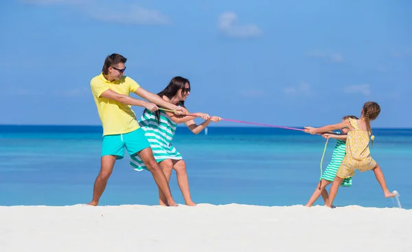 Famille heureuse jouant ensemble sur la plage blanche — Photo