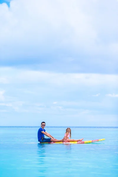 Kleine Mädchen und junger Papa haben Spaß auf dem Surfbrett — Stockfoto