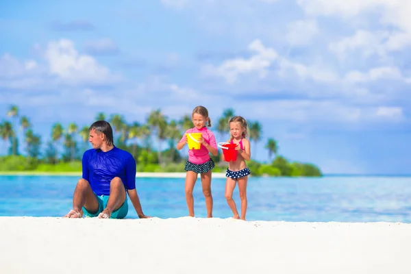 Sevimli küçük kızlar eğleniyor baba ile beyaz kumsalda — Stok fotoğraf