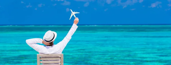 Jeune homme avec miniature d'un avion à la plage tropicale — Photo
