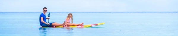 Kleine Mädchen und junger Papa haben Spaß auf dem Surfbrett — Stockfoto