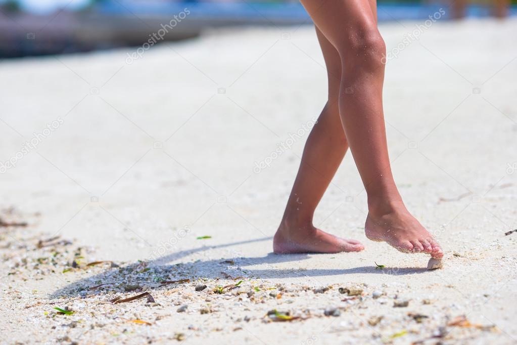 Closeup kid feet on white sand beach