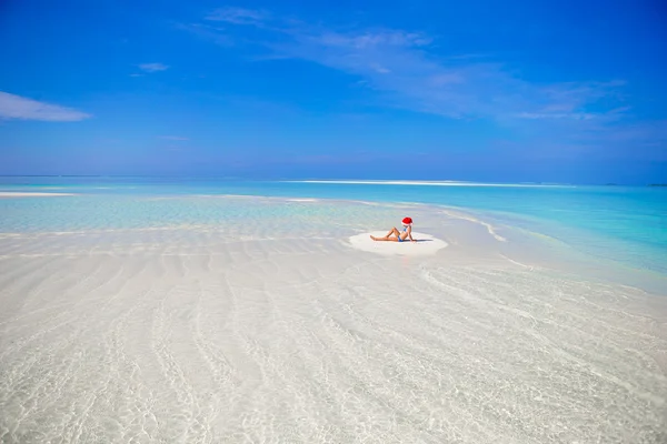 Adorable little girl in Santa hat on the beach during vacation — Stock Photo, Image