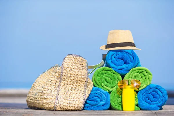 Concepto de accesorios de vacaciones de verano y playa: primer plano de toallas coloridas, sombrero, bolso y protector solar —  Fotos de Stock