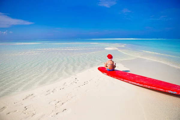 Adorable little girl in Santa hat on the beach during vacation — Stock Photo, Image